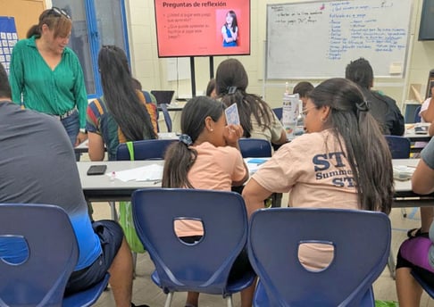Instructor leading a classroom of parents and children during a math learning session.